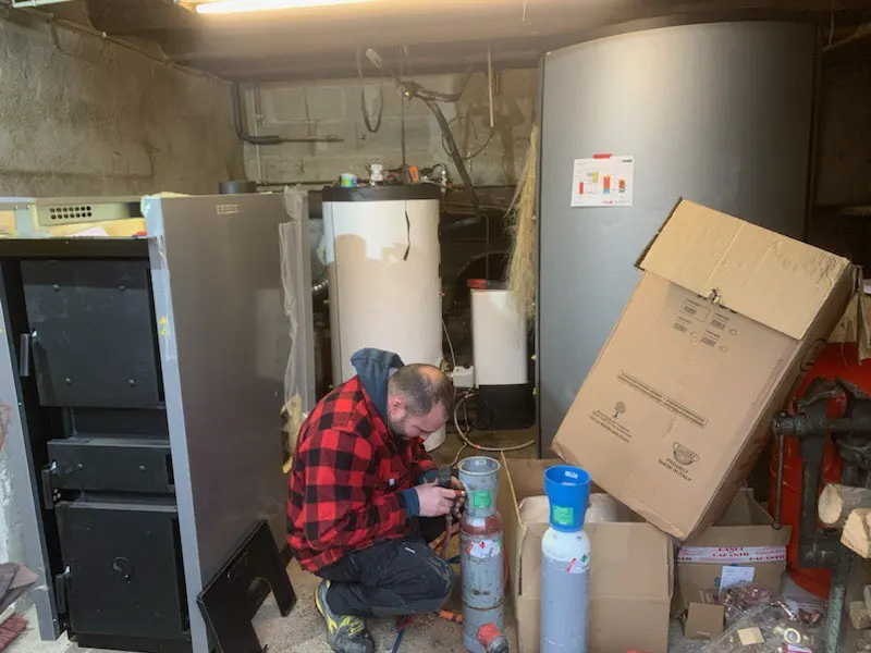 Technicien THERM'AVENIR pendant l'entretien d'une chaufferie à granulés en Nord-Isère