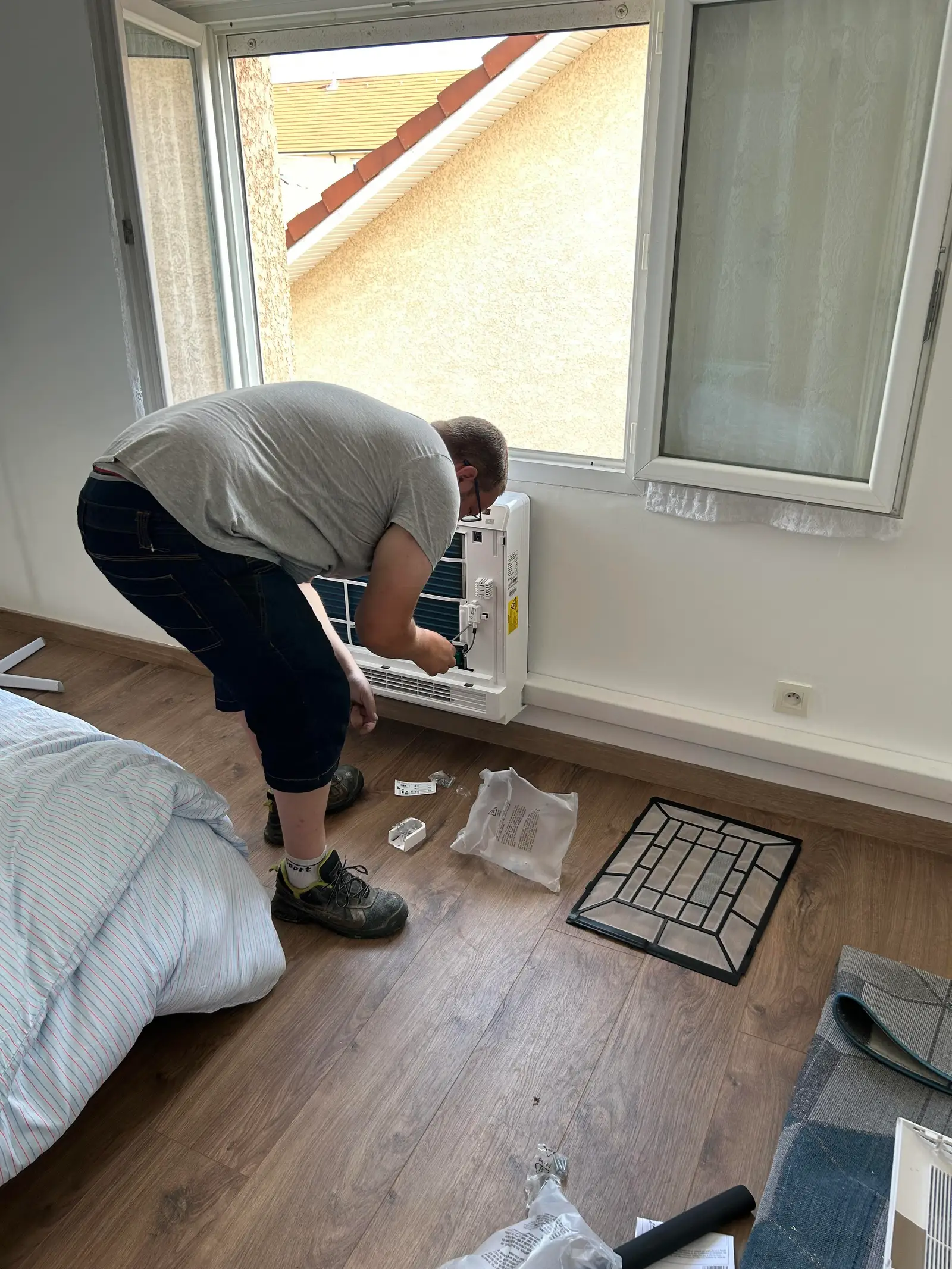 Maintenance climatisation Bourgoin-Jallieu — nettoyage d'un split mural par un technicien